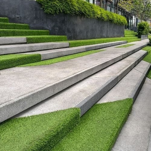Contemporary concrete steps landscaped with vibrant artificial turf